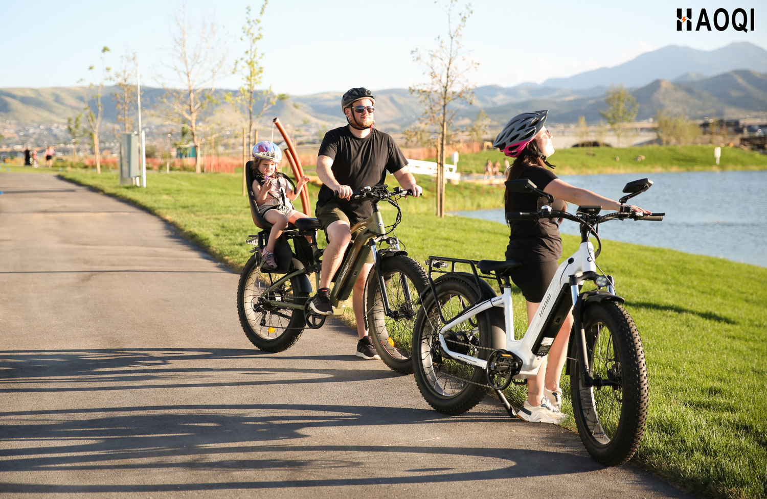 Eine glückliche Familie macht einen Ausflug im Sommer mit HAOQI E-Bikes, ideal für den perfekten Start in die Fahrradsaison dank der Juni-Angebote.
